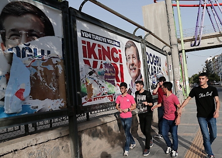 Jugendliche vor zerrissenen Wahlplakaten des türkischen Premierministers Davutoglu